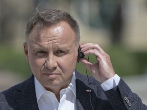 FILE - Polish President Andrzej Duda listens through an earpiece to Ukrainian President Volodymyr Zelenskyy during a joint news conference in Kyiv, Ukraine, Tuesday, Aug. 23, 2022. Russian comedians pretending to be the French president tricked the Polish president, Andrzej Duda, into giving them sensitive information after a missile exploded in eastern Poland last week. Duda's office confirmed on Tuesday, Nov. 22, 2022 that he was put through to a person claiming to be France's Emmanuel Macron last week.