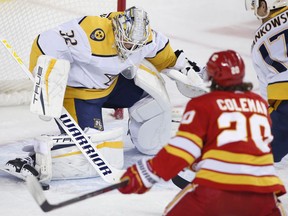Nashville Predators goalie Kevin Lankinen makes a save as Calgary Flames' Blake Coleman looks for a rebound during first period NHL hockey action in Calgary, Thursday, Nov. 3, 2022.
