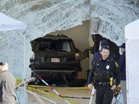 An SUV rests inside an Apple store behind a large hole in the glass front of the store, Monday, Nov. 21, 2022, in Hingham, Mass. One person was killed and 16 others were injured Monday when the SUV crashed into the store, authorities said.