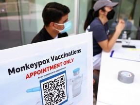 Health workers sit at a check-in table at a pop-up monkeypox vaccination clinic in West Hollywood on August 3, 2022.
