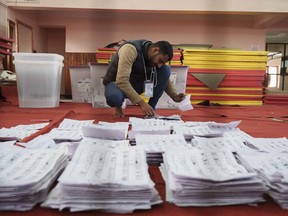 FILE- An election commission staff separates ballot papers to count a day after the general election in Kathmandu, Nepal, Nov. 21, 2022. Nepal's main ruling party was leading in last week's parliament elections as most of the votes were counted by Monday.