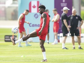 Canadian star Alphonso Davies kicks the ball during practice ahead of the World Cup in Doha, Qatar on Saturday, November 19, 2022.