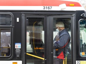 A TTC worker wears a mask in a bus while on shift in Toronto on Thursday, April 23, 2020.The Toronto Transit Commission says it's ending its mandatory COVID-19 vaccination requirement for workers and offering to reinstate employees who were terminated as a result of the policy.&ampnbsp;THE CANADIAN PRESS/Nathan Denette