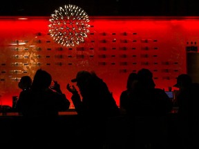 People are silhouetted as they sit in a bar having a drink in Toronto on Wednesday, March 30, 2022. Ontario's liquor regulator says restaurants and bars provincewide will be able to serve alcohol at 7 a.m. for the duration of the FIFA World Cup to align with some of the early-morning matches.