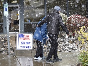Voters make their way into the Sparks Library to vote during a snow shoer in Sparks, Nev., Tuesday, Nov. 8, 2022. It is the first snow for the season for the Reno-Spark area.