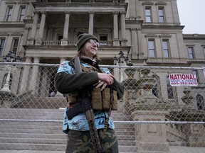 FILE = Timothy Teagan, a member of the Boogaloo Bois movement, stands with his rifle outside the state capitol in Lansing, Mich., Sunday, Jan. 17, 2021. Teagan who has described himself as a backer of the anti-government, pro-gun extremist movement called the boogaloo has been arrested by the FBI in Detroit. Teagan was expected to appear Wednesday, Nov. 2, 2022, in federal court when charges will be unsealed, said FBI spokeswoman Mara Schneider.