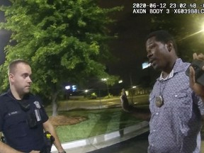 FILE - This screen grab taken from body camera video provided by the Atlanta Police Department shows Rayshard Brooks, right, as he speaks with Officer Garrett Rolfe in the parking lot of a Wendy's restaurant in Atlanta, on June 12, 2020. The Atlanta City Council on Monday, Nov. 21, 2022, voted to approve a $1 million settlement payment for the family of Brooks, who was shot and killed following a confrontation with two white police officers in June 2020. (Atlanta Police Department via AP, File)