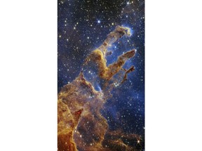 This image released by NASA on Wednesday, Oct. 19, 2022, shows the Pillars of Creation, captured by the James Webb Space Telescope in near-infrared-light view. (NASA, ESA, CSA, STScI via AP)