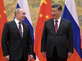 FILE - Chinese President Xi Jinping, right, and Russian President Vladimir Putin talk to each other during their meeting in Beijing, Friday, Feb. 4, 2022. The two leaders used the occasion of the Winter Olympics in Beijing to hold a summit and show solidarity.
