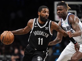 Brooklyn Nets guard Kyrie Irving (11) drives against Dallas Mavericks forward Reggie Bullock (25) during the second half of an NBA basketball game, Thursday, Oct. 27, 2022, in New York.