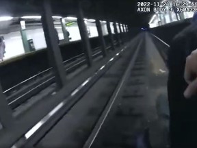 This image provided by NYPD shows police body cam video shows two New York City police officers and a bystander saving a man who fell on the tracks at a Manhattan subway station on Thursday, Nov. 24, 2022 in New York. The incident happened around 4 p.m. Thursday at the 116th Street station in East Harlem. The man, whom police said fell by accident, was taken to a hospital with injuries to his hand and back. (NYPD via AP)