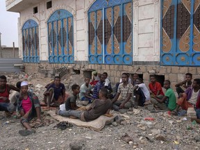 FILE - In this July 30, 2019, file photo, Ethiopian migrants chew Qat where they take shelter on a street in Marib, Yemen. Nearly all the migrants arriving in Yemen are East Africans.