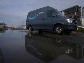 FILE - An Amazon Prime truck drives in Pacifica, Calif., on Dec. 15, 2020. Amazon has begun mass layoffs in its corporate ranks, becoming the latest tech company to trim its workforce amid rising fears about the wider economic environment.