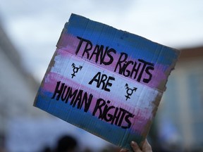 FILE - A demonstrator holds up a sign during a march to mark International Transgender Day of Visibility in Lisbon, March 31, 2022. At least 32 transgender and gender-nonconforming people have been killed in the United States in 2022, the Human Rights Campaign announced Wednesday, Nov. 16, in its annual report ahead of Transgender Day of Remembrance on Sunday, Nov. 20.