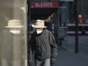 A pedestrian wears a mask as they walk through a quiet downtown in Toronto on Wednesday, April 7, 2021. Two government sources say Ontario's top doctor will recommend the public begin masking on Monday in an effort to help overwhelmed children's hospitals.THE CANADIAN PRESS/Tijana Martin