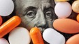 Capitalism and healthcare policy concept. Colorful medical pills cover Benjamin Franklin's face on one hundred american dollar bill. Macro top down view.