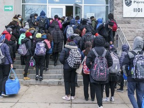 Students enter the Pierre Laporte Secondary School as secondary school students return to class full time during the COVID-19 pandemic in Montreal, on Monday, March 29, 2021. The Alberta government says school boards can't require students to wear masks in school or be forced to take classes online.THE CANADIAN PRESS/Paul Chiasson