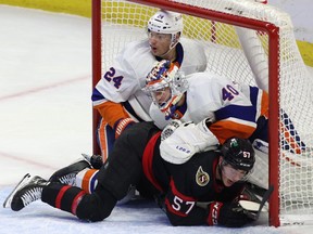 New York Islanders defenceman Scott Mayfield (24) and Ottawa Senators centre Shane Pinto (57) crash into goaltender Islanders goaltender Semyon Varlamov (40) during second period NHL hockey action in Ottawa on Monday, Nov. 14, 2022.