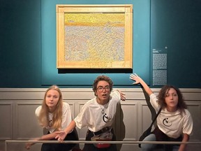 This photo obtained from Italian news agency Ansa on November 4, 2022 shows Climate activists from Last Generation posing by "The Sower," an 1888 painting by Dutch artist Vincent Van Gogh, after they threw pea soup at it on November 4, as it was on show at Rome's Palazzo Bonaparte.