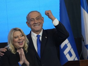 Former Israeli Prime Minister and the head of Likud party, Benjamin Netanyahu and his wife Sara gesture after first exit poll results for the Israeli Parliamentary election at his party's headquarters in Jerusalem, Wednesday, Nov. 2, 2022.