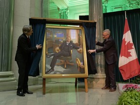 Artist Phil Richards, left, and former Premier Brad Wall, right, unveil Wall's official portrait at the Legislative Building in Regina on Wednesday, Nov. 30, 2022.