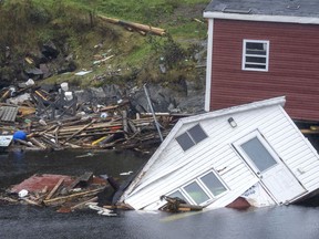 Buildings sit in the water along the shore following hurricane Fiona in Rose Blanche-Harbour Le Cou, N.L. on Tuesday September 27, 2022. The parliamentary budget watchdog says climate change has already begun to hurt the Canadian economy.