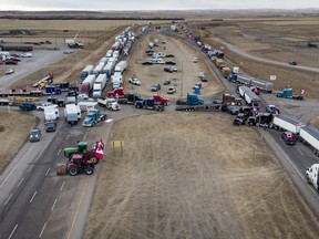 Anti-mandate demonstrators gather as a truck convoy blocks the highway the busy U.S. border crossing in Coutts, Alta., Monday, Jan. 31, 2022. Police in Lethbridge say there could be traffic congestion in the southern Alberta city as a convoy of vehicles arrives to support three men charged in the Coutts blockade.