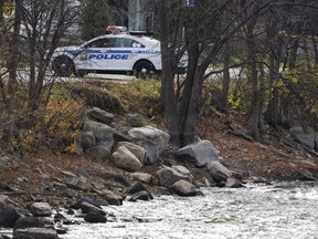 Police seal off the site where a missing one-month-old baby was found after a car crashed into the water of the Mille Îles river three days ago, in Laval, Que., on Oct. 31, 2022.