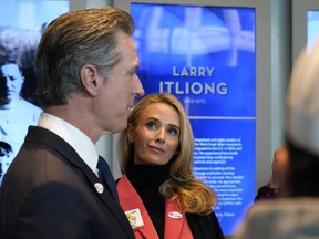 California Gov. Gavin Newsom talks to reporters after he and his wife, first partner Jennifer Siebel Newsom, right, voted in Sacramento, Calif., Tuesday, Nov. 8, 2022. Newsom is running for reelection against Republican state Sen. Brian Dahle.