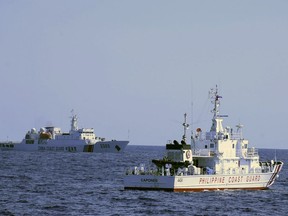 In this photo provided by the Philippine Coast Guard, a Chinese Coast Guard ship sails near a Philippine Coast Guard vessel during its patrol at Bajo de Masinloc, 124 nautical miles west of Zambales province, northwestern Philippines on March 2, 2022. The Philippines has sought an explanation from China after a Filipino military commander reported that the Chinese coast guard forcibly seized Chinese rocket debris in the possession of Filipino navy personnel in the disputed South China Sea, officials said Thursday, Nov. 24, 2022. (Philippine Coast Guard via AP)