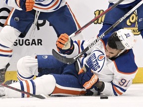 Edmonton Oilers forward Evander Kane (91) is knocked to the ice during the second period of an NHL hockey game against the Tampa Bay Lightning Tuesday, Nov. 8, 2022, in Tampa, Fla. Kane will miss three to four months after being cut on the left wrist by a skate blade during the play.