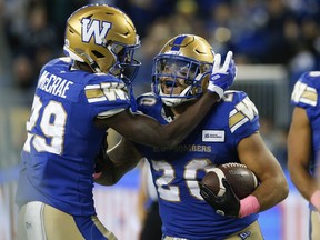Winnipeg Blue Bombers' Greg McCrae (29) and Brady Oliveira (20) celebrate Oliveira's touchdown against the Edmonton Elks during first half CFL action in Winnipeg on October 8, 2022. Oliveira will make his first post-season start at running back when the team hosts the B.C. Lions in Sunday's CFL West Division final at IG Field.