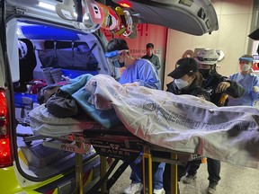 A miner rescued from a collapsed mine is carried into a hospital in Bonghwa, South Korea, Saturday, Nov. 5, 2022. Two South Korean miners rescued after being trapped underground for nine days said they had lived on instant coffee powder and water falling from the ceiling of a collapsed shaft.