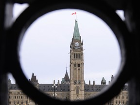 The Parliament Hill Peace Tower is framed in an iron fence on Wellington Street in Ottawa on Thursday, March 12, 2020. The federal government is asking Parliament to set aside $3 billion in anticipation of several out-of-court settlements with Indigenous people.THE CANADIAN PRESS/Sean Kilpatrick