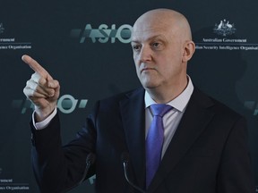 Australian Security Intelligence Organization director-general Mike Burgess points as he talks in Canberra, Australia, Monday, Nov. 28, 2022. Australia's terrorism threat level has been downgraded from "probable" to "possible" for the first time since 2014, the head of Australia's main domestic spy agency said on Monday.