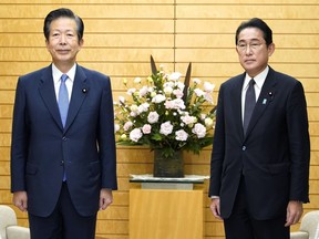 Japanese Prime Minister Fumio Kishida, right, and the leader of Kishida's coalition partner, Natsuo Yamaguchi pose for a photo as they meet to discuss a bill to help victims of the religious group known as the Unification Church, at the prime minister's official residence in Tokyo, Tuesday, Nov. 8, 2022.