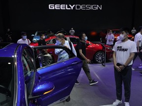 FILE - Visitors look at cars produced by Geely at the Auto China 2020 show in Beijing on Sept. 27, 2020. Renault SA and China's Geely announced plans Tuesday, Nov. 8, 2022 for a jointly owned venture to produce gasoline-powered and hybrid powertrains, adding to a series of partnerships between global automakers to share soaring technology costs.