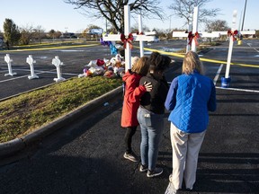 Sheree Perry of Virginia Beach, center, prays with chaplains at a memorial on Friday, Nov. 25, 2022 , for the six killed in a Chesapeake, Va., Walmart mass shooting earlier in the week.