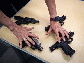 Seized firearms are displayed during an RCMP and Crime Stoppers news conference at RCMP headquarters in Surrey, B.C., on Monday, May 17, 2021. RCMP in Surrey, B.C., say homicide detectives have taken over the case of a man seriously injured in the latest shooting in that city.