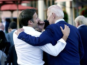 FILE - French President Emmanuel Macron whispers to U.S. President Joe Biden following their dinner at the G7 Summit in Elmau, Germany, June 26, 2022. Macron is heading to Washington for the first state visit of Biden's presidency--a reviving of diplomatic pageantry that had been put on hold because of the COVID-19 pandemic.