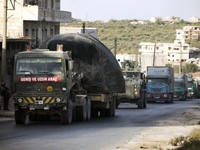 FILE - Turkish military convoy drives through the village of Urum al-Jawz, in Idlib province, Syria, Tuesday, Oct. 20, 2020. The Kurdish-led authority in northeast Syria called on residents on Saturday, Nov. 19, 2022 to unite against any possible attack by Turkey warning that such an offensive will lead to long war.