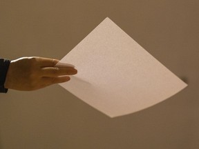 A person holds a piece of white paper during a protest gathering at the University of Hong Kong in Hong Kong, Tuesday, Nov. 29, 2022. On Tuesday, about a dozen people gathered at the University of Hong Kong, chanting against virus restrictions and holding up sheets of paper with critical slogans. Most were from the mainland, which has a separate legal system from the Chinese territory of Hong Kong, and some spectators joined in their chants.