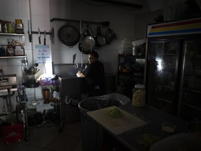 FILE - Workers at Las Palmas Cafe work with the power of an electricity generator during an island-wide blackout, in San Juan, Puerto Rico, April 7, 2022.