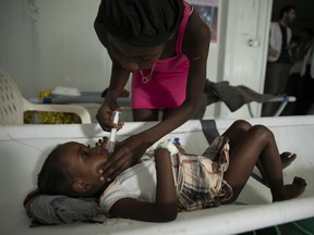 A girl with cholera symptoms is helped by her mother at a clinic run by Doctors Without Borders, in the Delmas neighborhood of Port-au-Prince, Haiti, Thursday, Nov. 10, 2022. Across Haiti, many patients are dying because say they're unable to reach a hospital in time, health officials say.