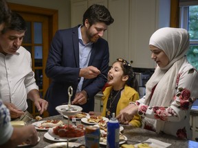 Tareq Hadhad, centre, enjoys the Nightingale's Nest ('Ish El Bulbul) dessert with his father and his siblings, from left to right, Ahmad Hadhad, Sana Alkadri, and Taghrid Hadhad at their home in Antigonish, N.S. on Aug. 2020.