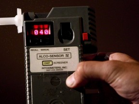 An RCMP Constable holds a breathalyzer test in Surrey, B.C., in this September 24, 2010 photo. A Quebec coroner's report has found that witnesses failed to report a drunk driver getting behind the wheel, leading to a fatal collision that caused the death of a family of four north of Quebec City in 2021.