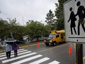 Students make their way to the first day of school at Sherwood Park Elementary in North Vancouver, Monday, Sept. 22, 2014. British Columbia's public school teachers have ratified a new three-year contract.
