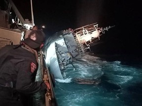 This handout photo taken on December 18, 2022 and released on December 19 by the Royal Thai Navy shows the HTMS Sukhothai warship on its side before sinking in the Gulf of Thailand, off the coast of Bang Saphan district in Prachuab Kiri Khan province. - At least 31 Royal Thai navy personnel were missing at sea after a vessel floundered in the Gulf of Thailand, a spokesperson said December 19.