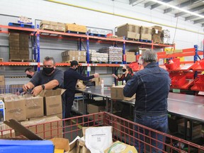 Volunteers tape boxes and sort through donated food at the Ottawa Food Bank warehouse in Ottawa in October. Canadian food bank demand has been unprecedently high in 2022.