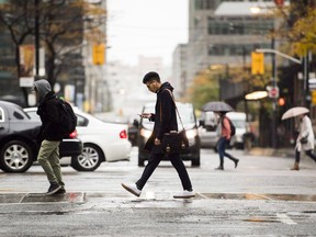 People cross the road in downtown Toronto on Friday, Nov. 2, 2018. Since the global onset of COVID-19, Canada has been gradually closing the gap with the United States when it comes to attracting and keeping an important economic prize: new permanent residents.